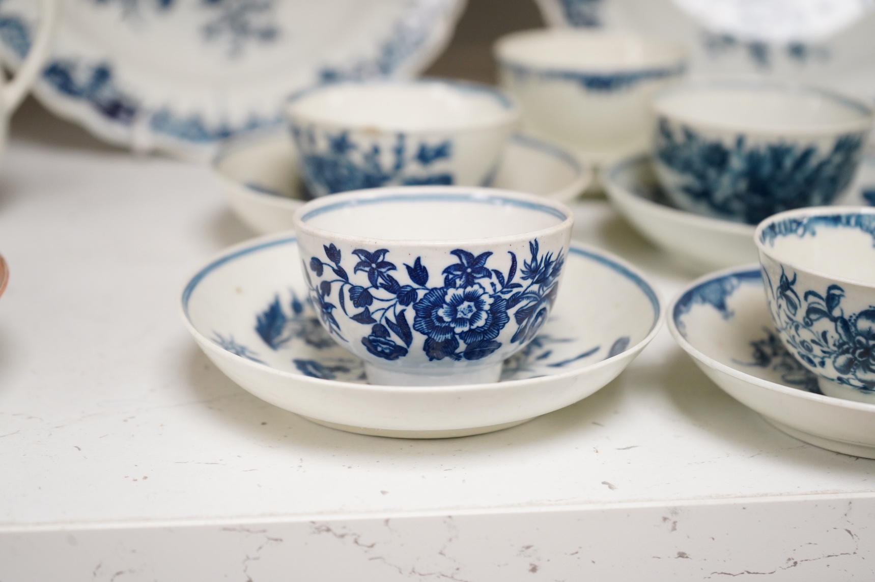 A collection of late 18th century Worcester, Caughley and Liverpool blue and white tea wares to include tea bowls and saucers, jug, suger basin and cover and two dishes etc, largest 23cm in diameter